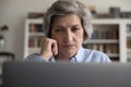 Close up serious concentrated middle-aged woman staring at laptop