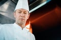 Close-up of a serious-faced chef working in a professional restaurant kitchen