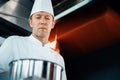 Close-up of a serious-faced chef working in a professional restaurant kitchen
