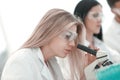 Close up.serious female scientist looking into microscope in lab Royalty Free Stock Photo