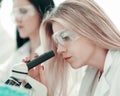 Close up.serious female scientist looking into microscope in lab Royalty Free Stock Photo