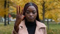 Close-up serious focused african american woman standing outdoors looking at camera counting from one to five counts