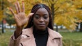 Close-up serious focused african american woman standing outdoors looking at camera counting from one to five counts