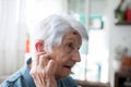 Senior woman adjusting in-ear hearing aid Royalty Free Stock Photo