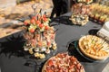 The close up of a set of canapes and snack at a banquet with black table
