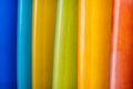 Close up Set of different color surf boards in a stack on sandy beach for rent. Multicolored surfboards as rainbow