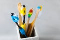 Close-up of a set of multicolored toothbrushes in a glass on a gray background Royalty Free Stock Photo