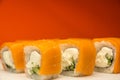 Close-up set of sushi fish salmon, cucumber, rice, cream cheese on a bright orange background.Sushi Philadelphia Shallow depth of