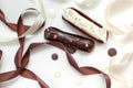 Close-up of a set of two eclairs with different fillings and design isolate on a white surface decorated with chocolate drops, Royalty Free Stock Photo