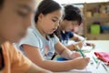 Close-up of several elementary school students doing an exercise in class Royalty Free Stock Photo