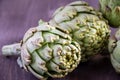 Close-up of several green artichokes, with selective focus, on wooden table