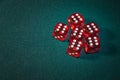 Close-up of several red dice with different digital combinations on green cloth in a casino