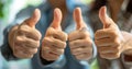 Multiple hands giving thumbs up in approval. Positive gesture, teamwork concept. Close-up, selective focus. Ideal for