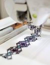 Close-up of sewing machine creating colorful abstract geometrical pattern on white fabric. Royalty Free Stock Photo