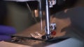 Close-up of sewing machine needle rapidly moves up and down.