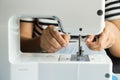 Close up of sewing machine and seamstress` hand