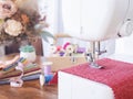 Close-up sewing machine working with red fabric, sewing accessories on the table, stitch new clothing Royalty Free Stock Photo