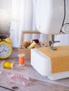 Close-up sewing machine working with yellow fabric, sewing accessories on the table, stitch new clothing Royalty Free Stock Photo