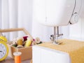 Close-up sewing machine working with yellow fabric, sewing accessories on the table, stitch new clothing Royalty Free Stock Photo