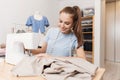 Close-up of sewing process, hands of seamstress hold fabric