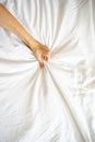 Close up sexy woman hand pulling and squeezing white sheets in ecstasy in bed. Orgasm on white bed. Sex and erotic Royalty Free Stock Photo
