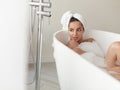 Close up of sexy young female taking relaxing bath with foam and bubbles in apartment. Caucasian beautiful woman in Royalty Free Stock Photo