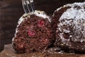 Close up shallow depth of field picture of chocolate cake cut into several pieces on the wooden rustic background