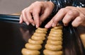 Female hands placing vanilla crescent roll cookies dough on black baking tray Royalty Free Stock Photo