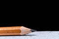 Close-up of a sharpened pencil on a textured surface.