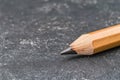 Close up of a sharpened pencil on a textured surface.