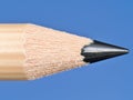 Close-up of a sharpened pencil tip against a blue background