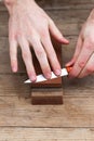 Close up of sharpening the knife with a whetstone on a wooden background. Top view Royalty Free Stock Photo