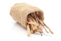 Close-up of Shatavari roots, in laying jute bag over white background.