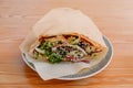 Close-up shawarma sandwich chicken roll in pita with fresh vegetables served on plate Royalty Free Stock Photo