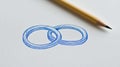 A close-up of a sheet with two interlocking blue circles hand-drawn in pen, resembling a basic sketch Royalty Free Stock Photo