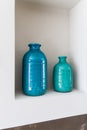 Close-up shelf detail of a bathroom with 2 green and blue vases. Royalty Free Stock Photo