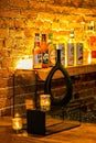 Close-up of a shelf of various types of alcoholic beverage bottles illuminated with light in a bar