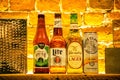 Close-up of a shelf of various types of alcoholic beverage bottles illuminated with light in a bar