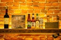 Close-up of a shelf of various types of alcoholic beverage bottles illuminated with light in a bar Royalty Free Stock Photo