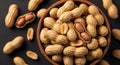 Close-up of Shelled Peanuts in a Wooden Bowl and Scattered on a Dark Surface unshelled in shell Royalty Free Stock Photo