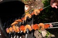 Putting chorizo shrimp skewers with red onions to cook on the barbecue Royalty Free Stock Photo