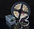 Close-up shine LED Light tape on spool and voltage adapter. Royalty Free Stock Photo