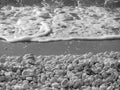Close up of shingle or rocky or pebble beach with smooth and round white sea stones . Black and white photo Royalty Free Stock Photo