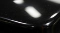 Close-up of a shiny black surface with subtle reflections of light, capturing details of dust Royalty Free Stock Photo