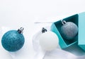 Close-up of shiny Christmas balls blue turquoise, white and silver color with ribbon on a white background. The concept of Royalty Free Stock Photo