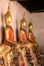 Close up shiny golden buddha statues in a row with beam of light Royalty Free Stock Photo