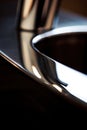 A close up of a shiny metal sink with the reflection, AI