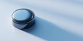 Close-up of a shiny metallic button casting a long shadow on a smooth light blue surface with soft lighting and minimalistic Royalty Free Stock Photo