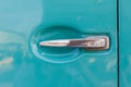 Close-up shiny steel car door handle retro style on turquoise ca Royalty Free Stock Photo