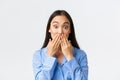 Close-up of shocked and astounded cute asian girl in blue pajama realise something, holding hands on mouth and pop eyes Royalty Free Stock Photo